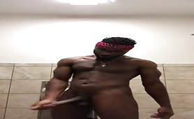 Muscular black guy stroking his dick in the gym bathroom 