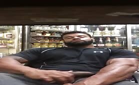 Big muscle guy stroking his cock in a liquor store