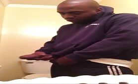 Horny black thug rubbing his cock in the toilet