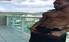 Gorgeous latin black dude jerking off on a balcony